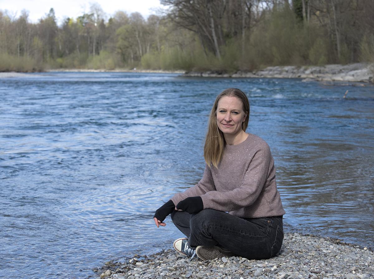 Nina sitzt an der Aare